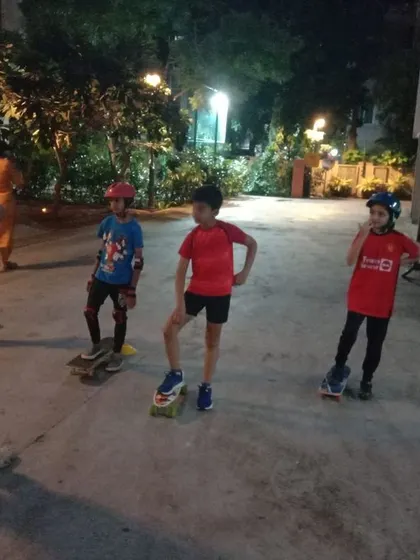 A group of kids on skateboards listens to their coach, ready to learn new tricks and techniques.