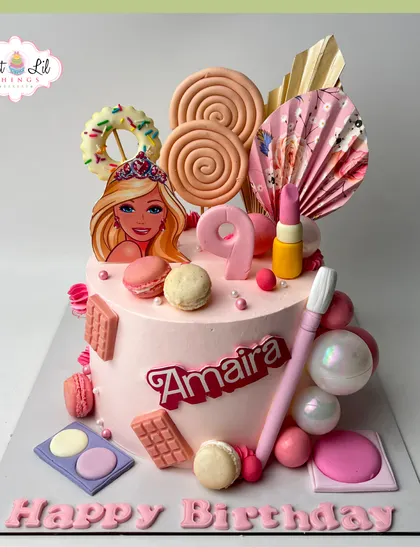 A Barbie and makeup-themed cake for Amaira's 9th birthday. This pink creation is loaded with edible lollipops, makeup brushes, and chocolate bars.