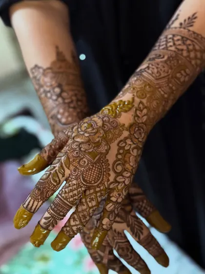 A creative shot of the party floral henna, with the hands posed to showcase the design's elegance.