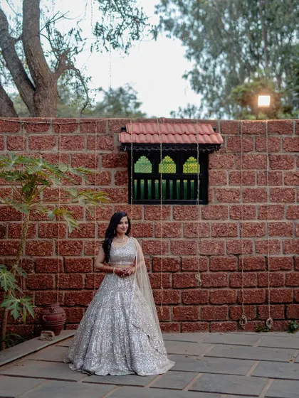 A wide shot of the bride against the beautiful brick wall and traditional window of the venue.