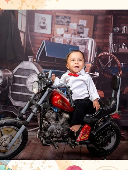 A happy little biker with a great smile. His joy is evident as he sits on the mini motorcycle, ready for an adventure.