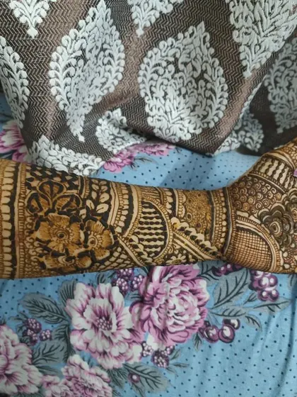 A side view of a detailed forearm mehendi band. This shows how the pattern wraps completely around the arm, ensuring the design looks beautiful from all angles.