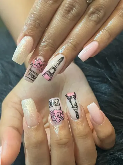 A close-up of our hand-painted "Parisian Love" design. This set features detailed illustrations of the Eiffel Tower and perfume bottles on long, square-shaped extensions.