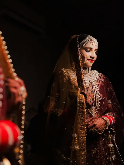 A quiet moment of reflection for the bride. This shot captures her looking at her reflection, a classic pose that speaks to the emotions and anticipation of the wedding day.