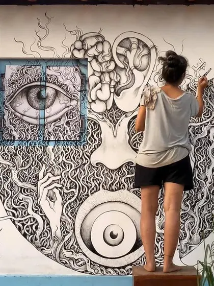 Here I am working on a large, complex mural in Gokarna. This piece shows how I integrate different elements like eyes, brains, and natural patterns into a single, cohesive abstract composition, all drawn freehand.