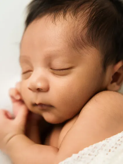 A tight close-up on a sleeping baby's face, showing their delicate eyelashes and soft skin. These minimalist portraits are pure and timeless.