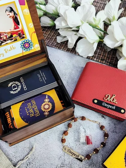 This Rakhi gift comes in a premium wooden box that can be customized with a picture on the lid. Inside, he'll find a personalized wallet, a Rudraksh rakhi, Denver perfume, and chocolate.