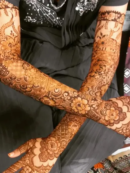 Another view of Aamina's stunning bridal henna, showing the crossed arm pose that highlights the symmetry and beauty of the design.