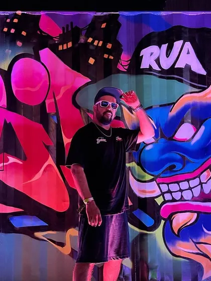 The art is everywhere. Posing in front of a massive, colorful graffiti piece in Thailand.