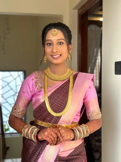 Dolled up my gorgeous bride for her pre-wedding rituals. This look features a beautiful pink and brown saree, complemented by simple gold jewelry and a soft, natural makeup look.