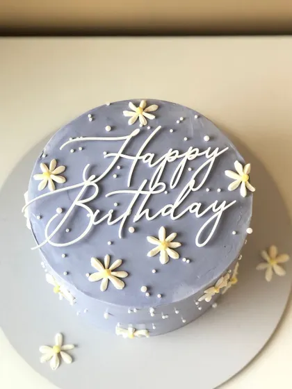 A minimalist Korean-style cake in a lovely periwinkle blue, with simple daisy decorations.