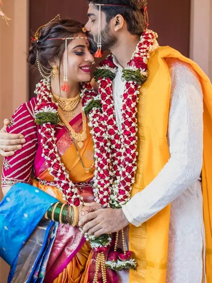A gentle kiss on the forehead after the main rituals. We focus on these small, intimate gestures that are full of emotion, set against the vibrant colors of the bride's Paithani saree and the groom's simple kurta.