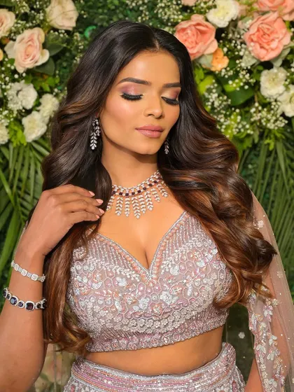 She is absolutely glowing. This lilac and pink toned makeup with soft smokey eyes and voluminous hair is the definition of modern reception glam.