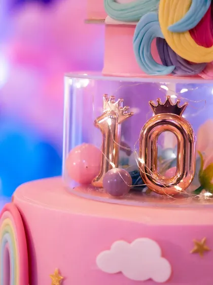 A birthday isn't complete without a cake. This multi-tiered unicorn cake was the centerpiece of the dessert table, surrounded by pastel balloons and rainbow decorations.