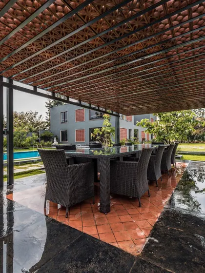 The covered outdoor dining pavilion, featuring a terracotta tile roof and overlooking the pool, perfectly exemplifies our approach to blurring indoor and outdoor spaces.