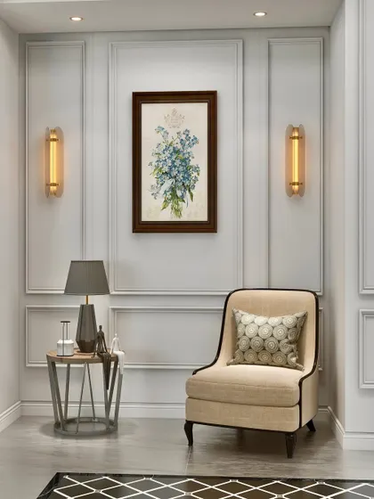 We transformed a simple corner into an elegant vignette. A classic armchair, a delicate side table, and carefully chosen art are framed by wall moldings and symmetrical sconces, demonstrating how even small spaces can be imbued with purpose and style.