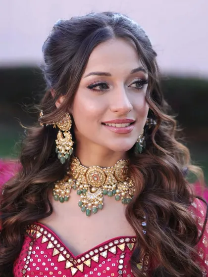 A beautiful Bhaat ceremony look. The makeup is soft and romantic, with a focus on defined eyes and a natural lip, letting her stunning pink lehenga shine.