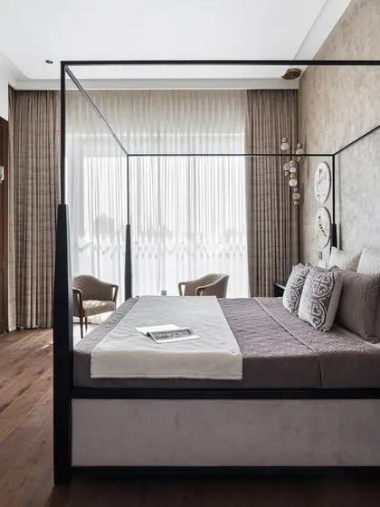 This master bedroom is designed as a serene retreat, blending modern and heritage styles. The four-poster bed creates a striking centerpiece, while the vintage writing desk and earthy textures add warmth and character, making it a truly personal sanctuary.