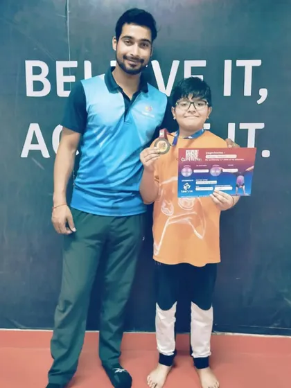 This student proudly displays his medal and certificate, a double achievement.