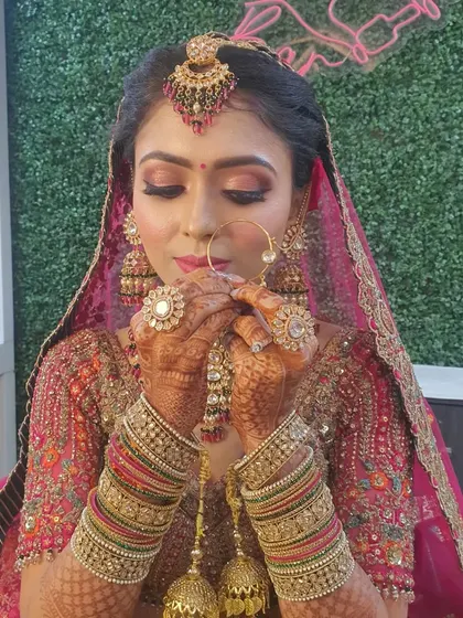 A beautiful candid moment of the bride admiring her look. The makeup is designed to look stunning from every angle, with a focus on glowing skin and expressive eyes.