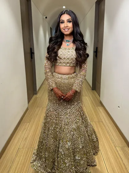 A full-length view of a bride ready for her sangeet. I styled her hair in long, flowing curls to match the grand and glamorous feel of her golden lehenga.