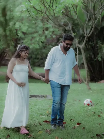 This walking shot captures the easygoing and happy dynamic of the couple during their casual maternity session in a beautiful green space.