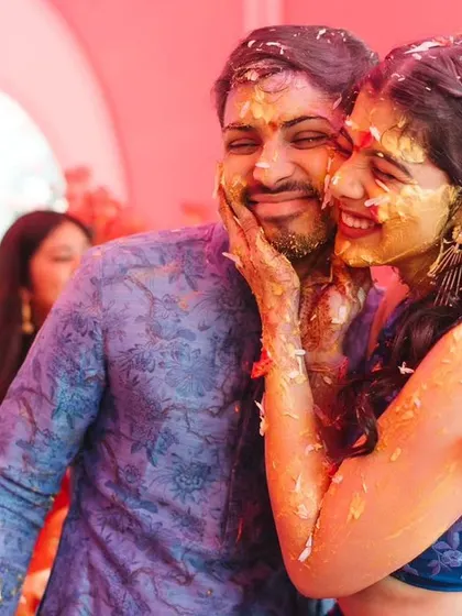 The couple sharing a playful moment, covered in haldi and smiles, during their unconventional and fun-filled Haldi ceremony.