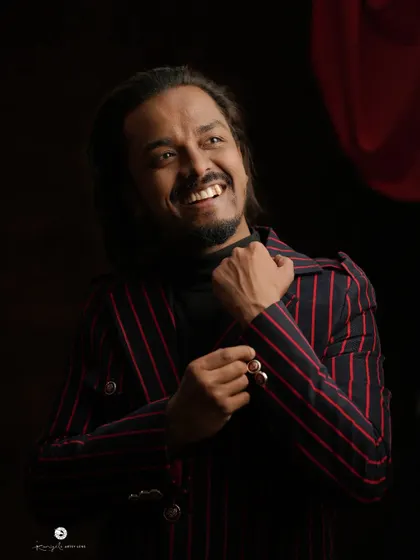 A candid shot of me wearing my red and black pinstripe jacket. I believe a good suit should not only look great but also feel comfortable and reflect your personality.