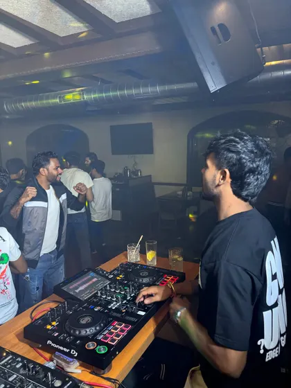 A candid moment at the DJ console, preparing the next track while the party rages on.
