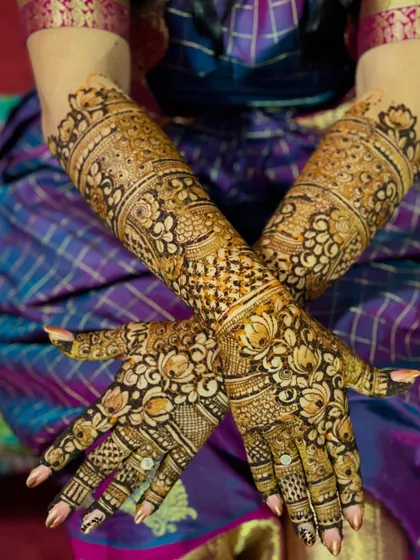 A crossed-hands view of the traditional lotus and jaali design, showing the beautiful symmetry and flow of the patterns.