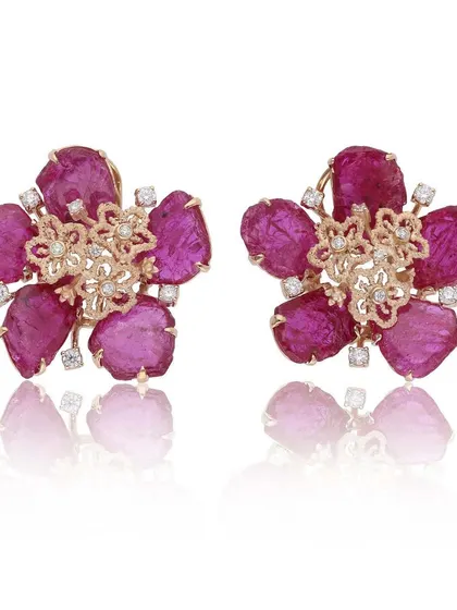 These rose like ear tops feature rough, unheated Mozambique rubies, with only the top layer polished to reveal their raw beauty. They are set in handcrafted 18k gold floral motifs, embracing organic elegance.