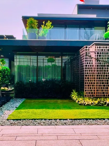 A look at the front facade of the Sultanpur farmhouse, where I used a mix of a small lawn, gravel beds, and carefully sculpted topiary trees. This approach creates a formal yet welcoming entrance that is low-maintenance and visually striking.