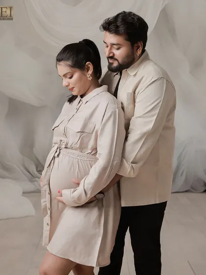 A quiet, connected pose in our studio. The couple, dressed in matching neutral tones, shares a peaceful moment together.