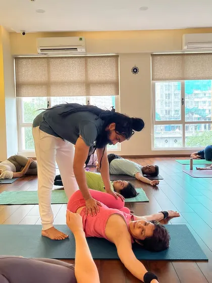 Assisting with a supine twist to help release the lower back. Personal attention ensures you get the most out of every stretch.
