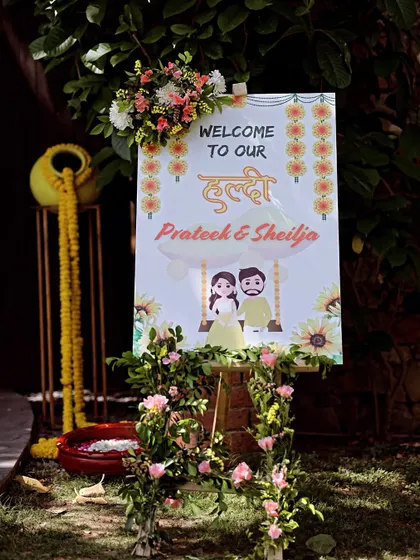 A custom welcome sign for Prateek and Sheilja's Haldi, decorated with a floral garland, setting a warm and inviting tone.