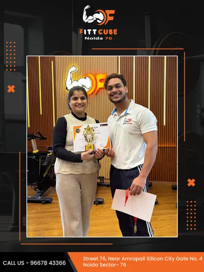 We love celebrating our members' success. A client receives her certificate and a trophy from one of our trainers, recognizing her hard work and dedication.
