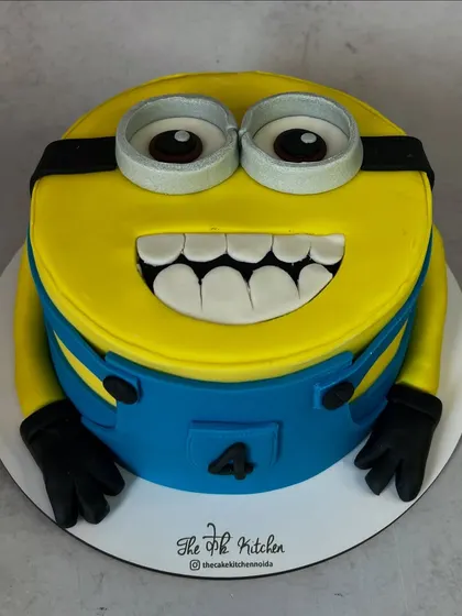 A fun and cheerful Minion cake, designed to look just like the character's face. The goggles and wide grin are made from fondant, making it a hit at kids' parties.