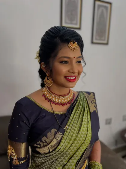 This bride is all smiles, looking radiant in her beautiful silk saree. I gave her a fresh makeup look with a classic red lip that perfectly suits the traditional attire for her wedding function.