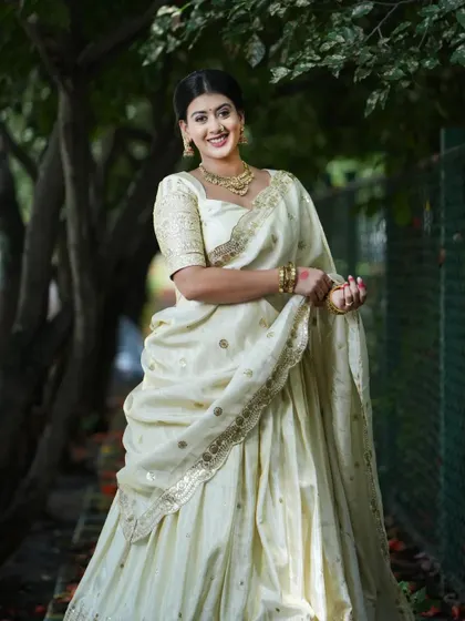 The smile of a happy client in her elegant white half saree, a symbol of peace and purity.