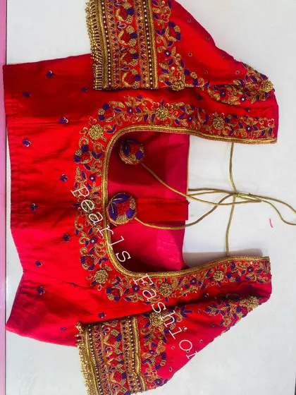 A bright red blouse with heavy gold and purple embroidery. I added custom-made fabric balls (potli buttons) to the back for a unique design element.