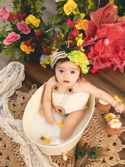 A sweet baby girl dressed as Radha taking a milk bath. This is a fun and unique way to celebrate the festival and capture adorable photos.
