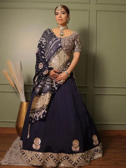 A classic bandhani lehenga by Faabiiana, styled for a sophisticated look. The deep navy blue is complemented by a statement polki necklace, showcasing how traditional textiles can be styled for modern elegance.