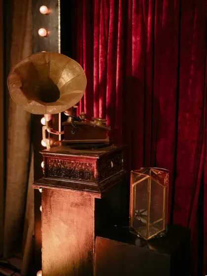 A vintage gramophone adds a touch of old world charm and nostalgia to the decor. It's a perfect prop for a retro or classic themed event.