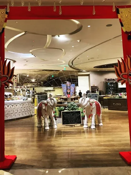 The entrance to a Sri Lankan Food Festival, featuring a traditional red archway, Gini Raksha masks, and decorated elephant statues. This bold entrance immediately sets the cultural tone for the event.