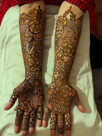 A full view of a floral henna design on both arms, showcasing the symmetry and intricate patterns.