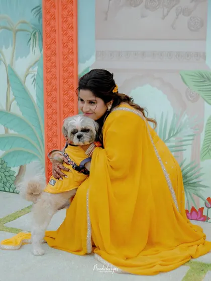 A heartwarming moment between the bride and her furry friend, both dressed for the occasion. This shows the importance of including all family members in the celebration.