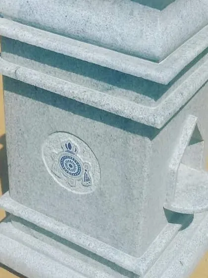 A custom-made stone pillar with a carved emblem and a small alcove, suitable for use as a gate post or a decorative garden feature.