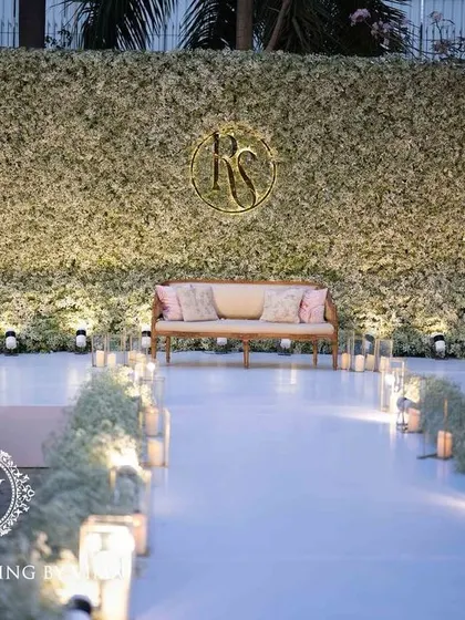 An ethereal all-white reception. The aisle and backdrop are adorned with clouds of baby's breath, while flickering candles cast a warm, romantic glow, creating a scene straight out of a fairy tale.