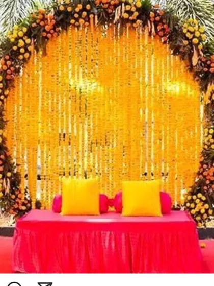 Our most requested Haldi backdrop design. A large ring of marigolds frames a curtain of genda strings, with a simple diwan for seating, perfect for any outdoor pre-wedding event.