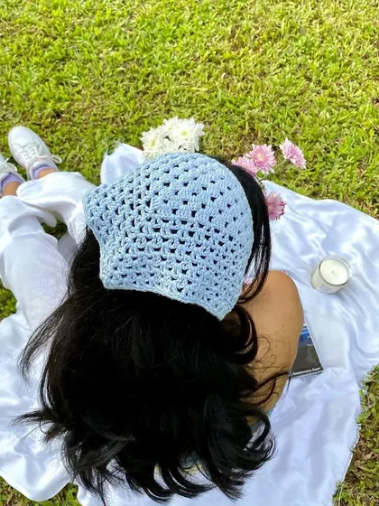 An overhead shot showing the detail of the crochet bandana. The open stitch pattern is delicate and stylish.